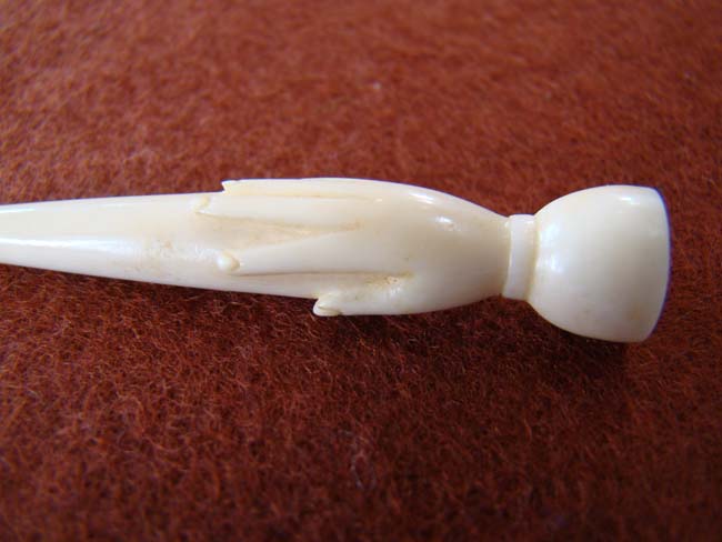 A 19th century carved 'Whale Ivory' bodkin with open hand terminus